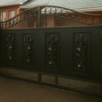 Элегантные уличные распашные кованые ворота с ажурным узором на въезде в частный дом в Бресте.